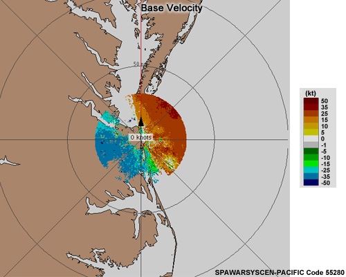 Military radar system base velocity image showing shades of blue and green to the west of the radar and shades of orange and red to the east of the radar.