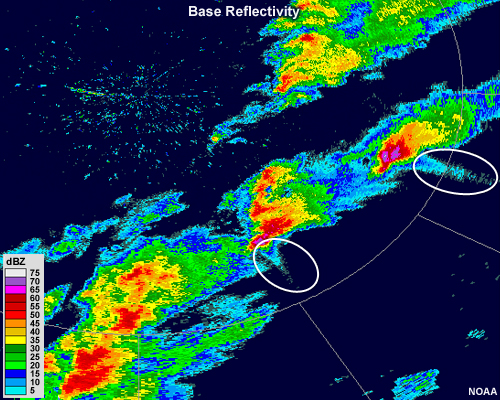 Two large thunderstorm cells with reflectivities of 75+ dBZ in their cores also have protrusions of narrow bands of low reflectivity extending downrange from the radar.