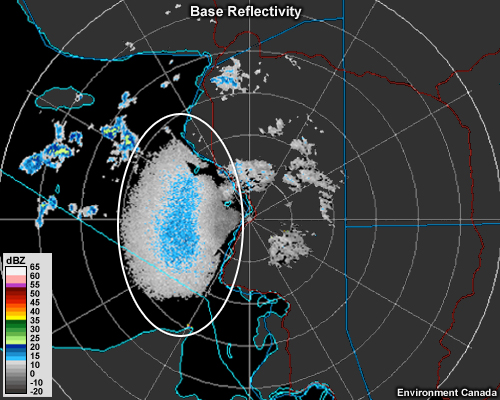A radar reflectivity image shows a large grainy-looking area of low-intensity echo just to the west of a coastline.